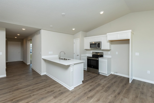 6570 NE 11th Ct, Des Moines, IA 50313 - kitchen featuring stainless steel appliances, a sink, vaulted ceiling, white cabinetry, and wood finished floors