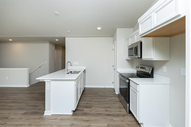 6570 NE 11th Ct, Des Moines, IA 50313 - kitchen with stainless steel appliances, a sink, a peninsula, light wood-style flooring, and white cabinets