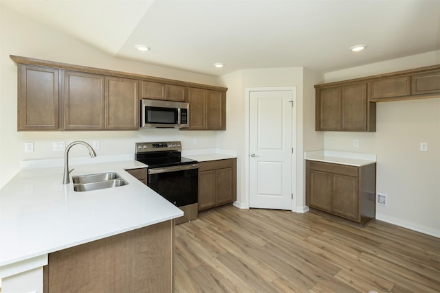6573 NE 11th Ct, Des Moines, IA 50313 - kitchen with appliances with stainless steel finishes, a sink, recessed lighting, light wood finished floors, and light countertops