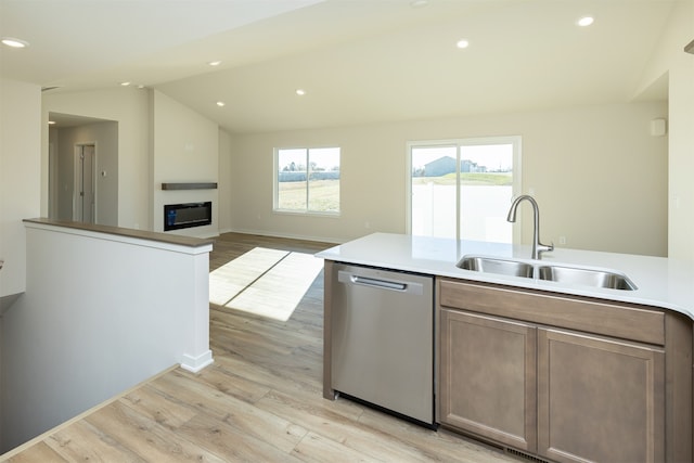 kitchen featuring dishwasher, light hardwood / wood-style floors, lofted ceiling, and sink