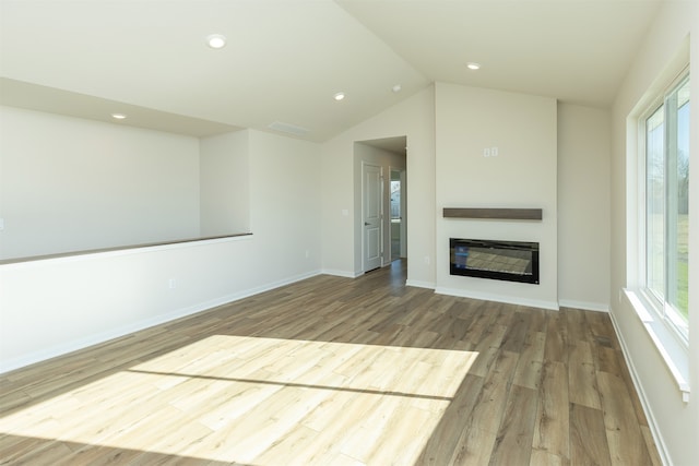 unfurnished living room featuring hardwood / wood-style flooring, a healthy amount of sunlight, and vaulted ceiling