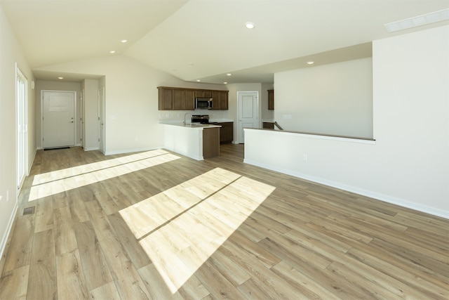 unfurnished living room with light wood-type flooring and lofted ceiling