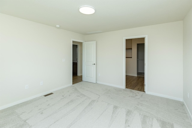 6573 NE 11th Ct, Des Moines, IA 50313 - unfurnished bedroom with carpet, a spacious closet, and baseboards