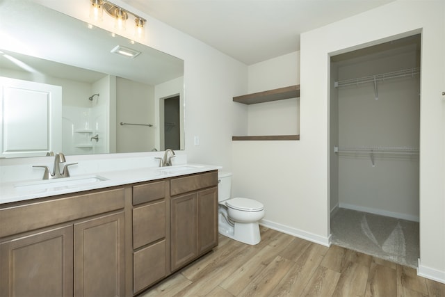 bathroom with toilet, a shower, vanity, and hardwood / wood-style flooring