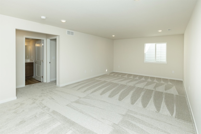 unfurnished room featuring light carpet