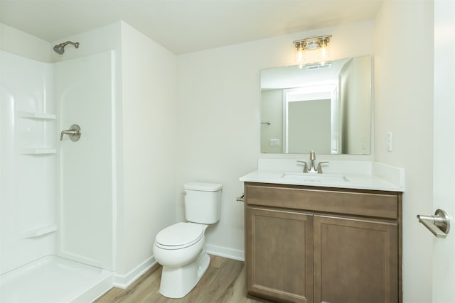 bathroom featuring walk in shower, wood-type flooring, toilet, and vanity