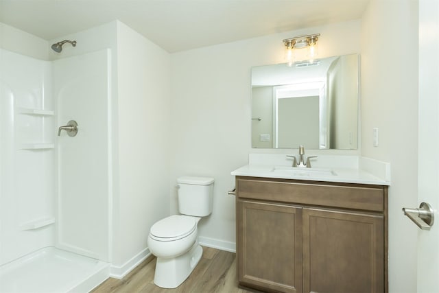 6573 NE 11th Ct, Des Moines, IA 50313 - full bath with toilet, a shower, wood finished floors, vanity, and baseboards