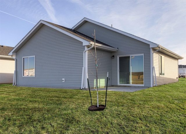 rear view of property featuring a yard and a patio area