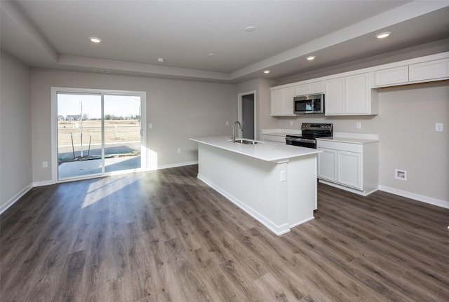 kitchen with sink, white cabinets, dark hardwood / wood-style flooring, stainless steel appliances, and a center island with sink