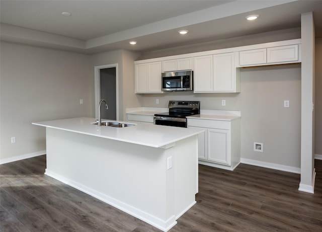 kitchen with stainless steel appliances, white cabinetry, a kitchen island with sink, and sink