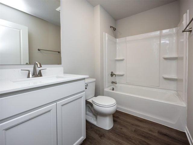 full bathroom with vanity, hardwood / wood-style floors, washtub / shower combination, and toilet