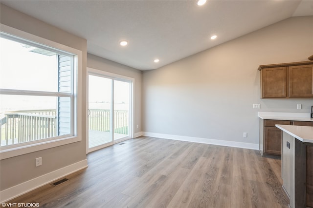 interior space with lofted ceiling and light hardwood / wood-style floors