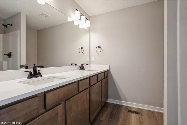 bathroom with vanity, a shower, a textured ceiling, and hardwood / wood-style floors