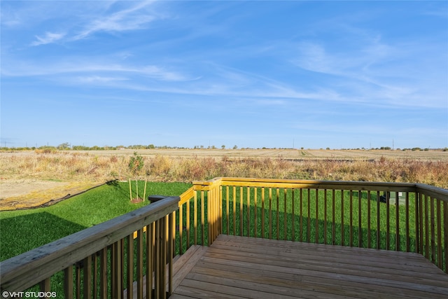 wooden deck with a lawn and a rural view