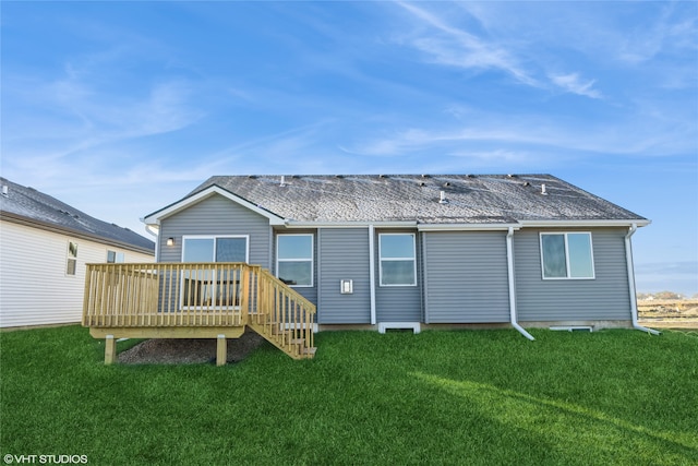 back of property featuring a wooden deck and a lawn