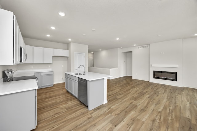 kitchen featuring sink, a kitchen island with sink, stainless steel appliances, and light hardwood / wood-style floors