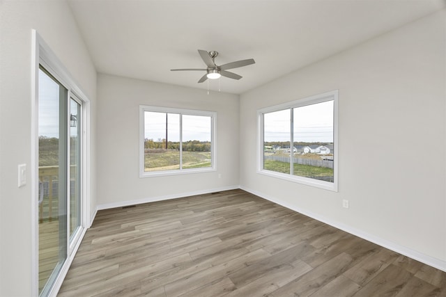 unfurnished room with light wood-type flooring and ceiling fan