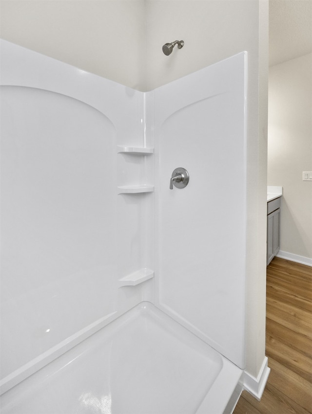 bathroom with vanity, walk in shower, and wood-type flooring