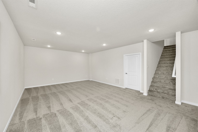 carpeted empty room featuring a textured ceiling