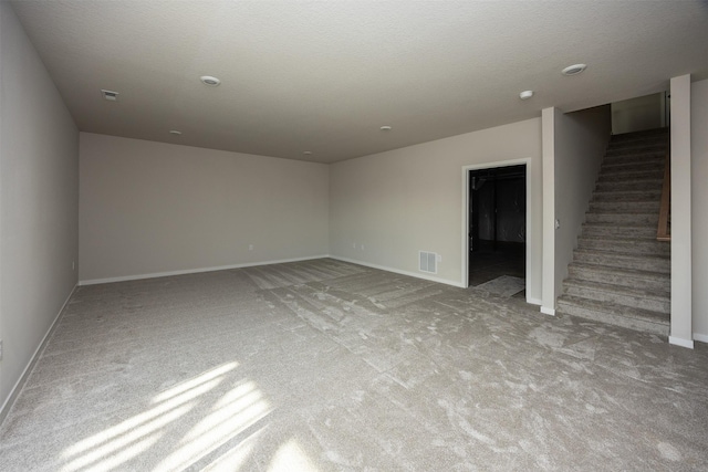 unfurnished room featuring light carpet and a textured ceiling