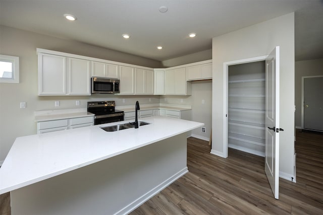 kitchen featuring dark hardwood / wood-style flooring, stainless steel appliances, a kitchen island with sink, sink, and white cabinetry