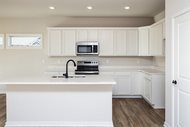 kitchen with an island with sink, sink, white cabinets, and stainless steel appliances