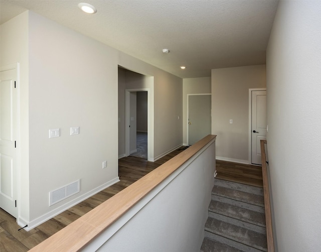 stairs featuring wood-type flooring and a textured ceiling