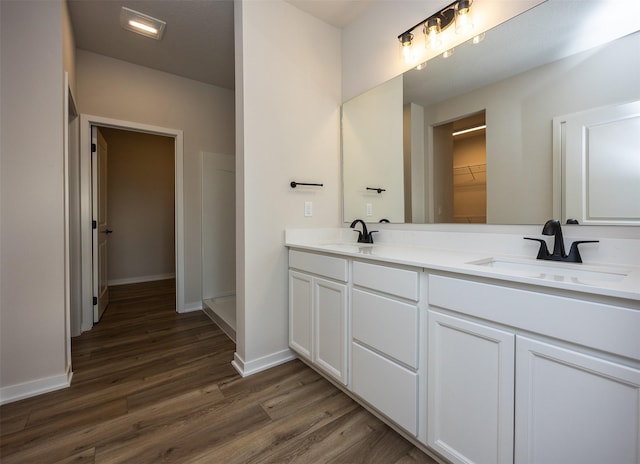 bathroom featuring vanity, wood-type flooring, and walk in shower