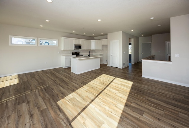 kitchen featuring black / electric stove, white cabinetry, dark hardwood / wood-style flooring, and a kitchen island with sink