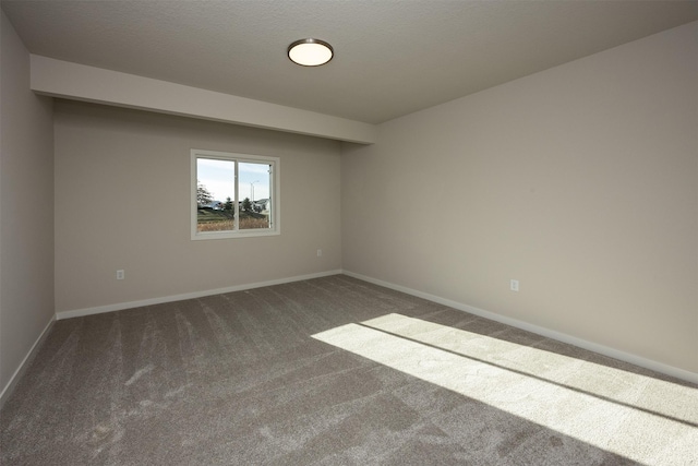 carpeted empty room featuring a textured ceiling