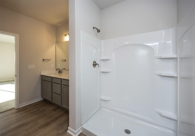 bathroom with hardwood / wood-style floors, vanity, and walk in shower