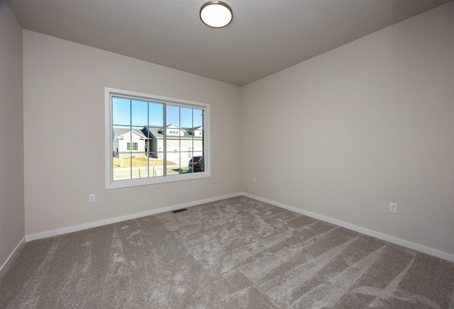 carpeted empty room featuring a textured ceiling