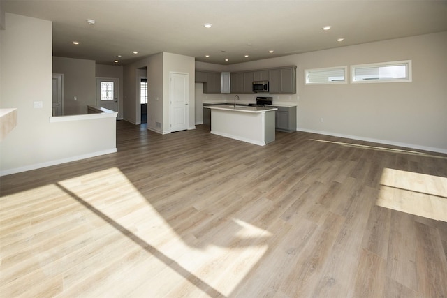 unfurnished living room with light wood-type flooring and sink