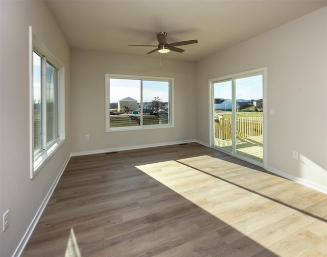 empty room with dark hardwood / wood-style flooring and ceiling fan