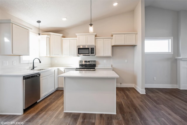 kitchen with appliances with stainless steel finishes, pendant lighting, and lofted ceiling