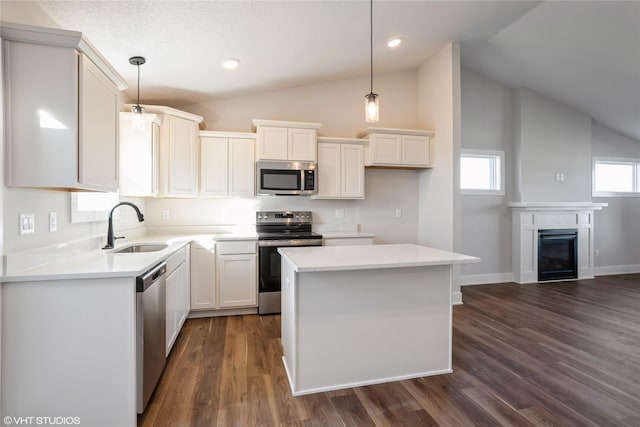 kitchen featuring decorative light fixtures, dark hardwood / wood-style floors, a kitchen island, and stainless steel appliances