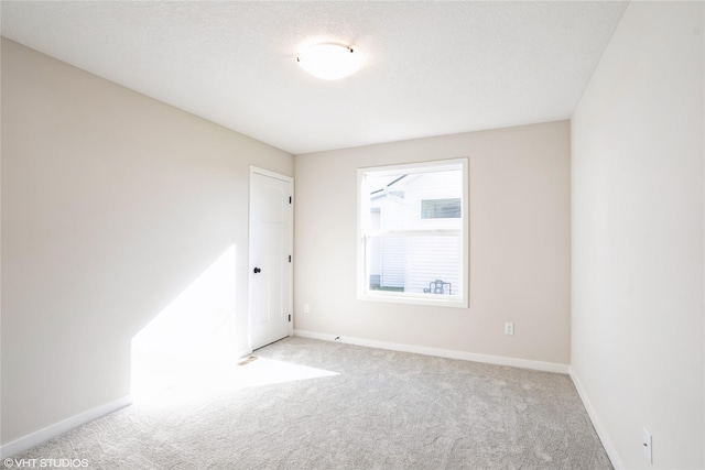 carpeted empty room with a textured ceiling