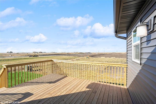 wooden terrace featuring a lawn and a rural view