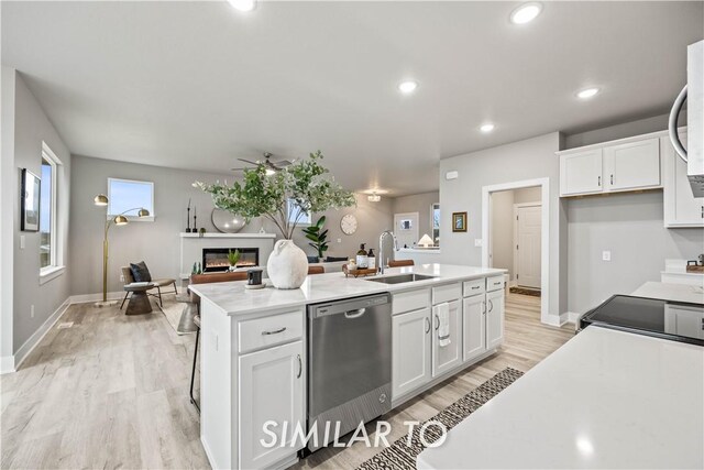 kitchen with sink, white cabinetry, a center island with sink, dishwasher, and ceiling fan