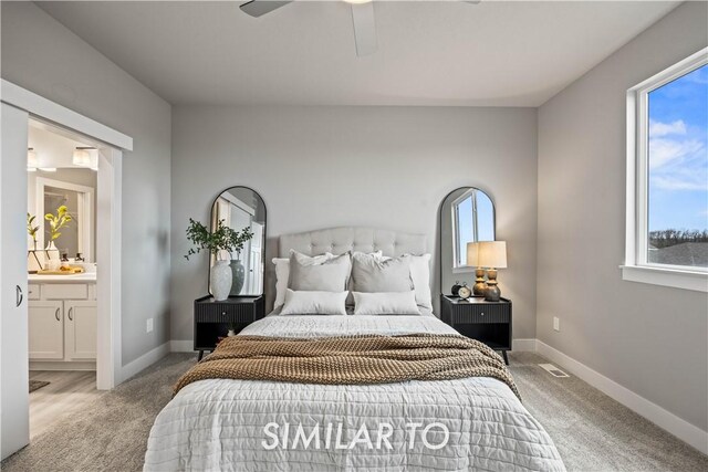 carpeted bedroom featuring ensuite bath and ceiling fan