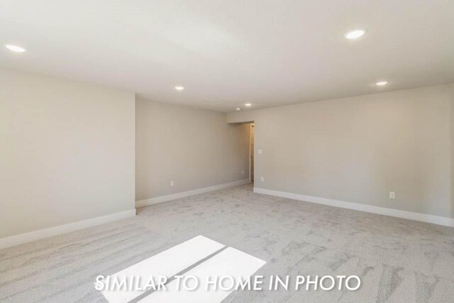 unfurnished room featuring light colored carpet