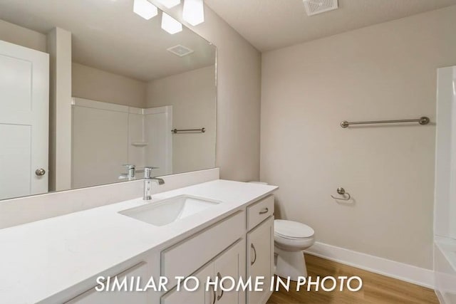 bathroom with vanity, wood-type flooring, and toilet