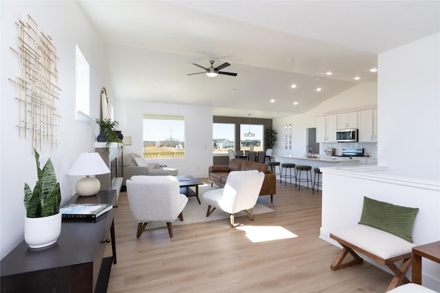 living room featuring ceiling fan, light wood-type flooring, vaulted ceiling, and recessed lighting