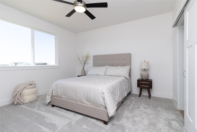 bedroom featuring ceiling fan, baseboards, and light colored carpet