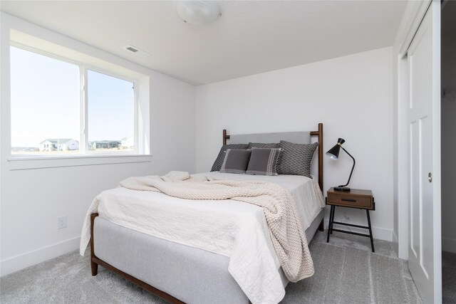 bedroom with carpet floors, a closet, visible vents, and baseboards