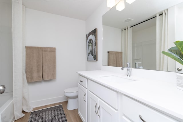 full bath featuring visible vents, toilet, vanity, wood finished floors, and baseboards