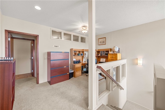 carpeted bedroom with ceiling fan and a textured ceiling