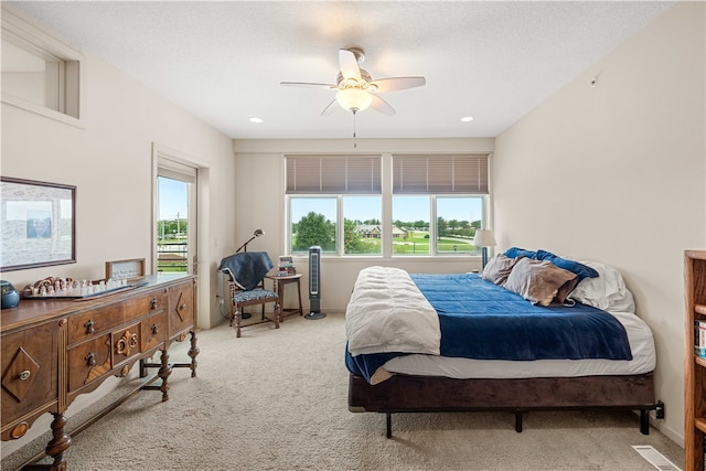 carpeted bedroom featuring multiple windows, ceiling fan, and a textured ceiling