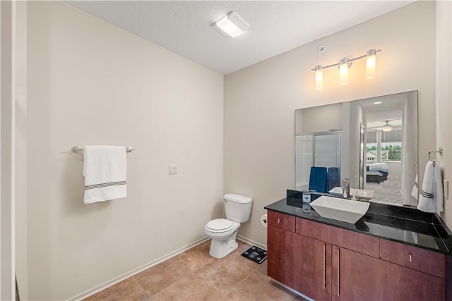 bathroom with a textured ceiling, vanity, an enclosed shower, and toilet