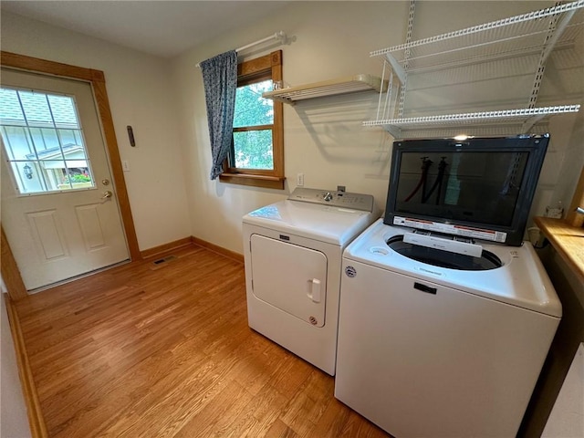 washroom featuring a wealth of natural light, light hardwood / wood-style floors, and independent washer and dryer